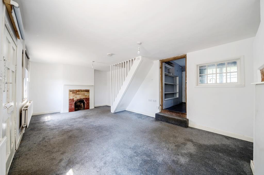 Lot: 48 - VACANT TWO-BEDROOM TERRACE HOUSE - Living room with fire place and access to kitchen